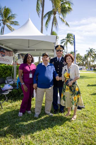 people posing for picture with man in World War II Veteran hat