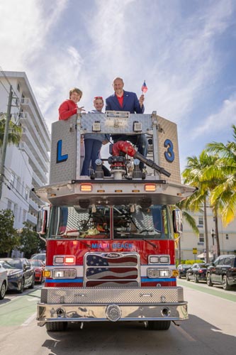 City Manager, Eric Carpenter, and two children on top of Miami Beach fire truck