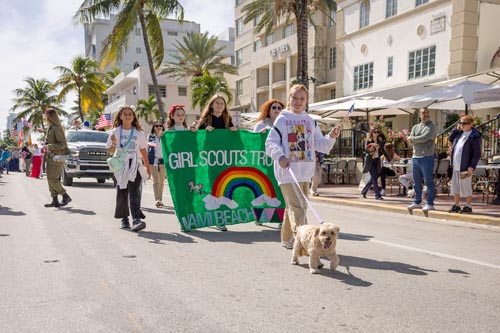 Girl Scouts walking with sign