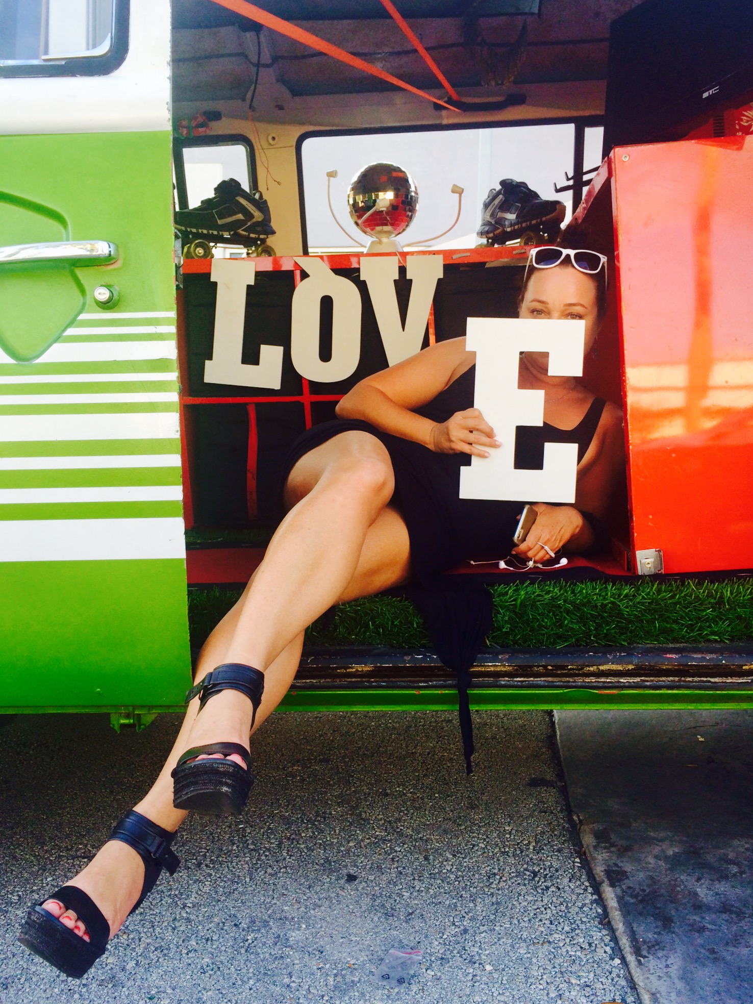 woman posing in a car holding the letters spelling out "love"